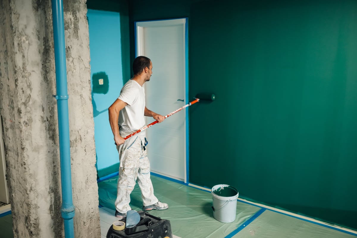 Professional painter applying paint to an interior wall